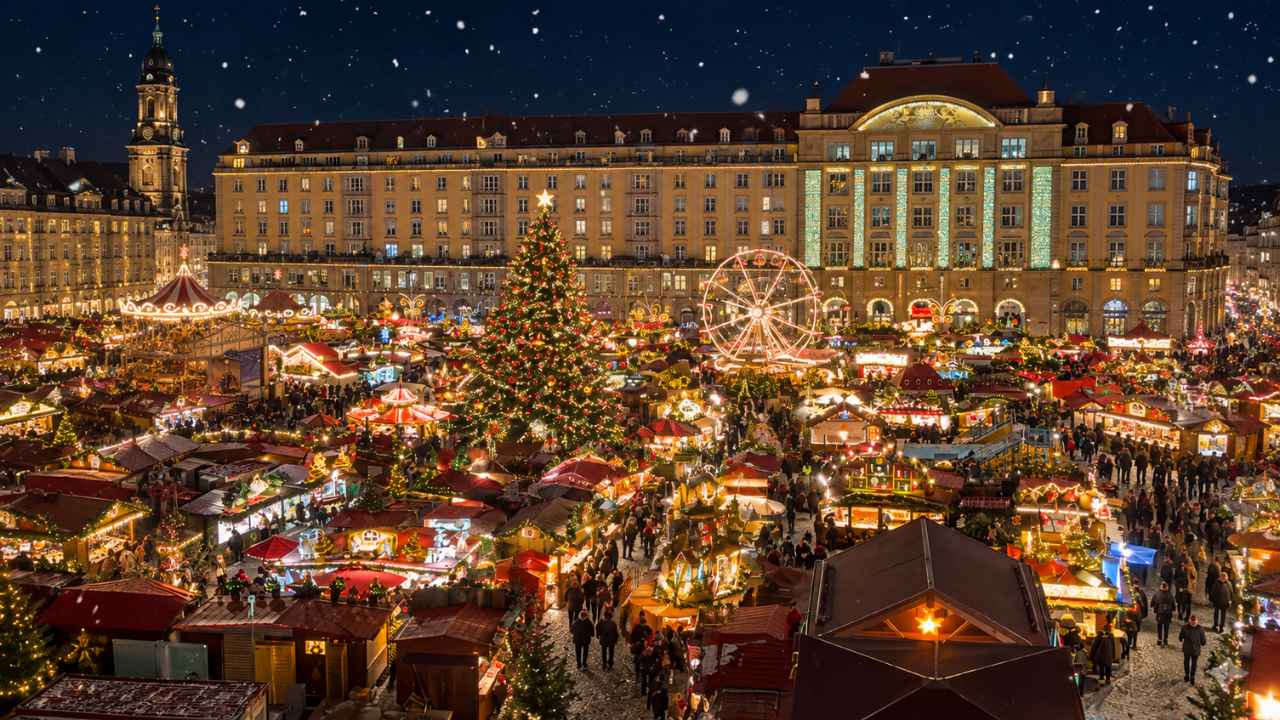 Pasar Natal Eropa pada malam hari: deretan stan kayu bercahaya, pohon Natal besar, bianglala, dan bangunan bersejarah bersalju