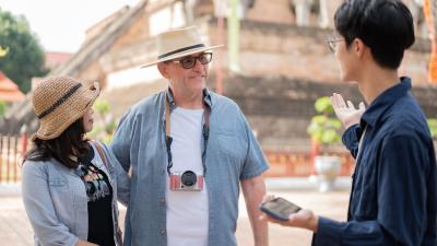 Listening to a guide talking standing aside ancient pagoda in buddhist temple